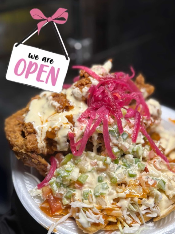 Fried chicken piled over plantain tajadas with cabbage slaw and pickled red onion